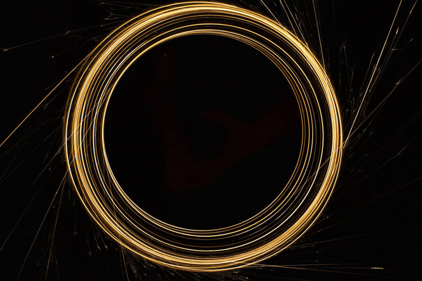 Kör alakú lámpák szikrákkal fekete alapon - Fotó, kép