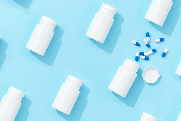 Padrão com pílulas jar vitaminas bio aditivos em um fundo azul com sombras profundas. Farmácia de cuidados de saúde e medicina conceito - Foto, Imagem