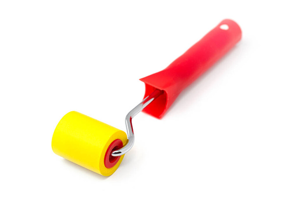 Yellow rubber paint roller on a white background. - Foto, afbeelding