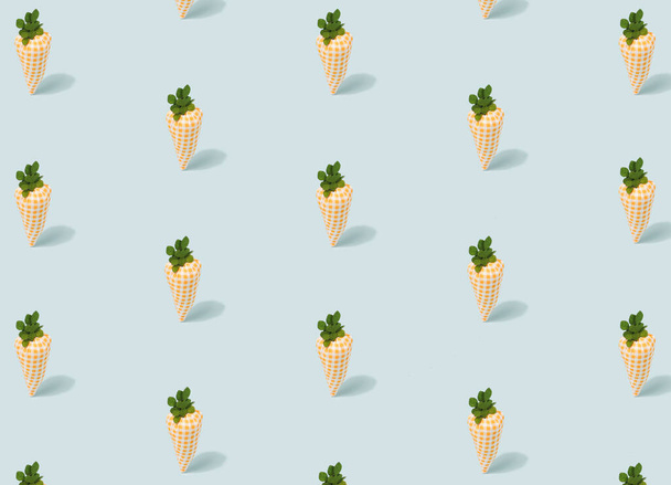 Cute toy carrots pattern on a light blue background. Springtime, Easter minimal template. - Photo, Image
