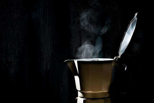 Moka pot with smoke on black background.soft focus. - Photo, Image