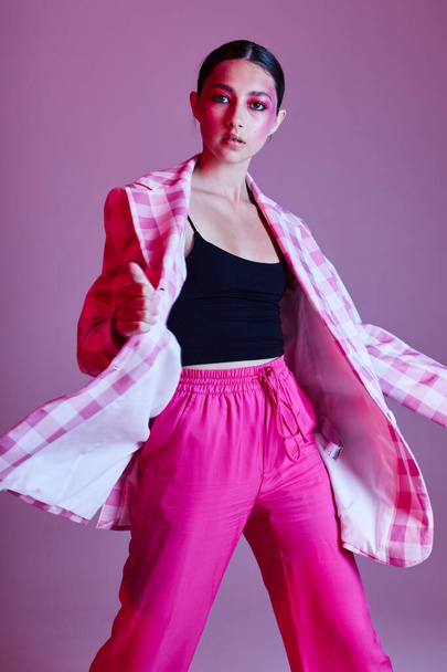 Young beautiful woman plaid blazer fashion posing luxury pink background unaltered - Фото, зображення