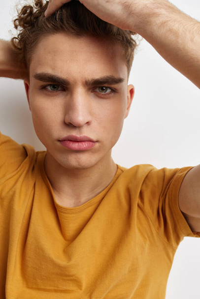 handsome young man in yellow t-shirts gesture hands emotions isolated background - 写真・画像
