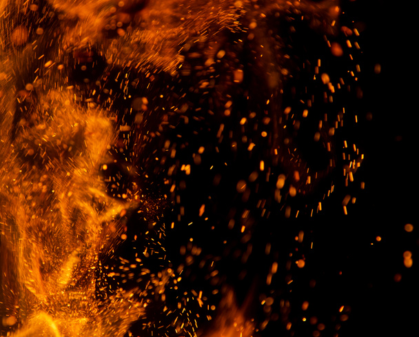 vuur vlammen met vonken op een zwarte achtergrond - Foto, afbeelding