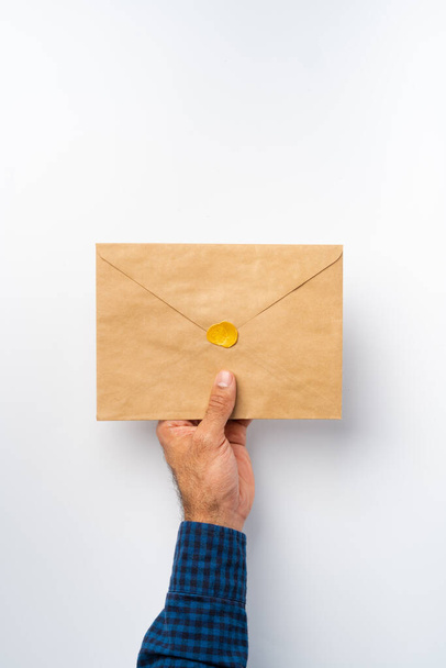 Male hands holding an envelope with a wax seal - Foto, Imagen