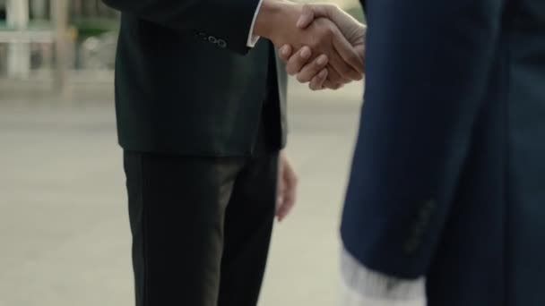 Close up Asian businesspeople shaking hands with partnership deal while standing outside on the street near a big office building urban. - Footage, Video