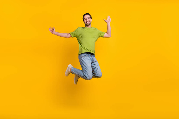 Full length photo of youth guy excited good mood jump up travel isolated over yellow color background. - Photo, image