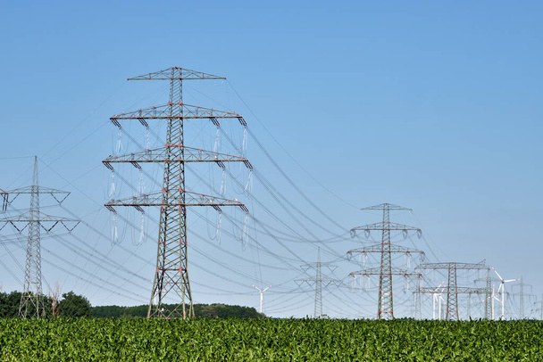 Pylônes et lignes électriques avec éoliennes à l'arrière vu en Allemagne - Photo, image