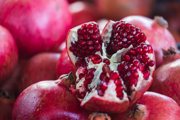Close-up of bright fruits for background, texture. Red ripe pomegranates on display. - Photo, Image