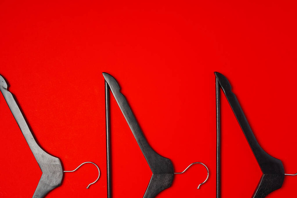 Hanger on red paper background. Minimalistic fashion concept. Top view - Foto, imagen
