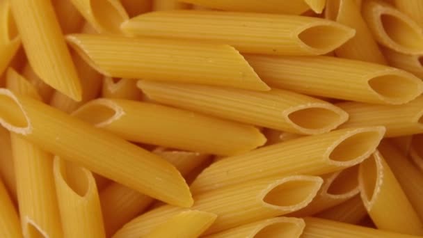 Rotatie rauwe droge pasta penne, Vegetarisch gezond biologisch voedsel Dieet, Macro, Italiaanse pasta klaar om te worden gekookt - Video
