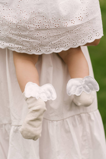 The legs of a cute little girl and socks with wings - Foto, Imagem