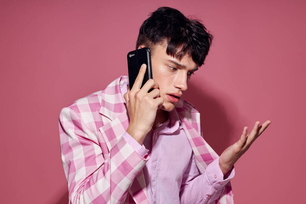 Photo of romantic young boyfriend with a phone in hand pink blazer fashion elegant style Lifestyle unaltered - Fotó, kép