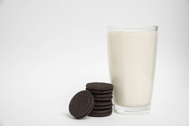 Čokoládové sušenky s mlékem ve sklenici na bílém pozadí - Fotografie, Obrázek