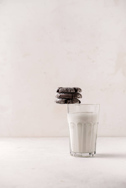 Selbst gebackene Schokolade knackte Kekse auf einem Glas Milch gestapelt - Foto, Bild