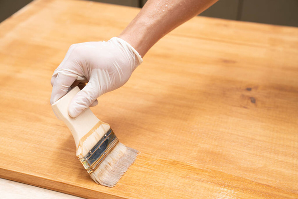 Applying protective varnish on a wooden furniture - Фото, изображение