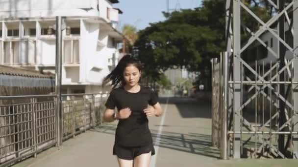 Gyönyörű ázsiai nő sportoló fut tesztelés intenzív kardió kitartás edzés a városi városban. A kocogás egészséges életmód. - Felvétel, videó