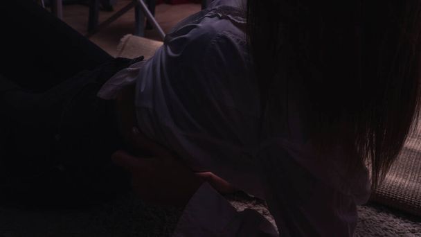 Tmavá fotka mladé krásné smyslné a sexy ženy s dlouhými vlasy na sobě v bílé košili pózuje ve studiu.   - Fotografie, Obrázek