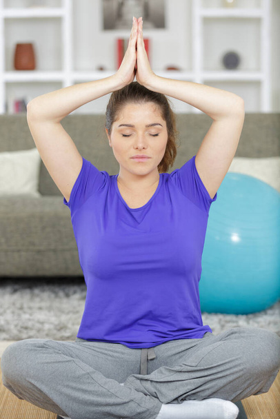 a woman practicing home yoga - Фото, изображение
