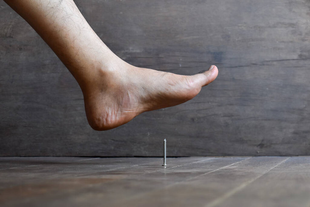 Ранение ногтевого укола в ногу азиатского молодого человека. Концепция столбняка. - Фото, изображение