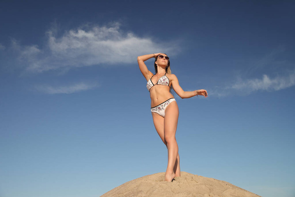 молодая спортсменка в купальнике на песке - Фото, изображение