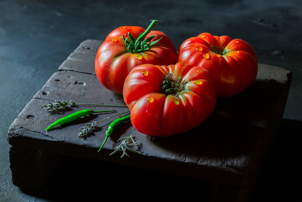 Tomaten auf schwarzem Hintergrund in natürlichem Licht geschossen - Foto, Bild