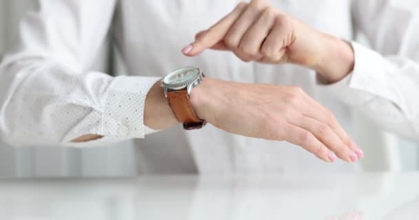 Businesswoman points to wristwatch on hand closeup - Footage, Video