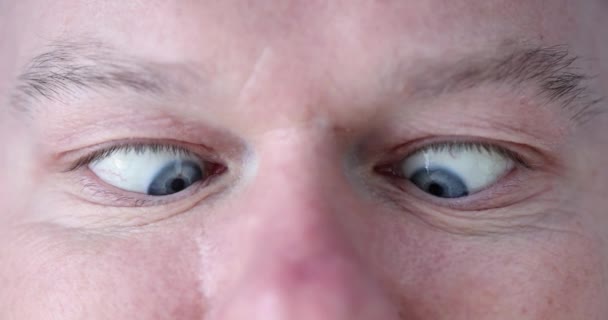 Junger Mann mit blauen Augen macht Augenübungen in Nahaufnahme - Filmmaterial, Video