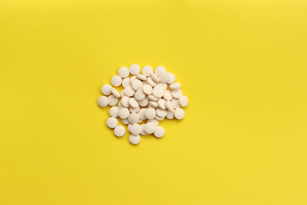 Witte pillen op een gele achtergrond. Geneeskunde - Foto, afbeelding