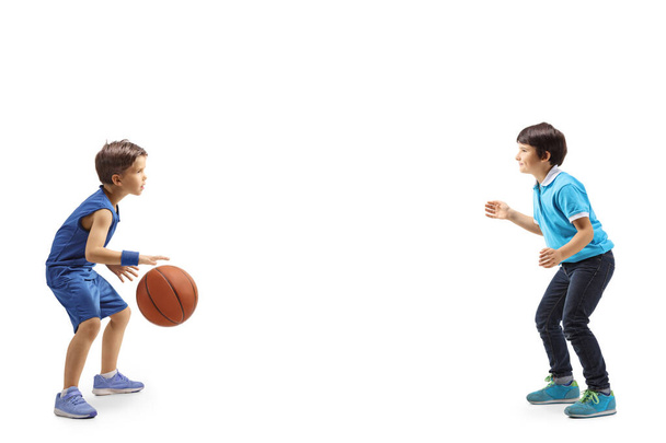 Full length profile shot of two boys playing basketball isolated on white background - Foto, Imagem