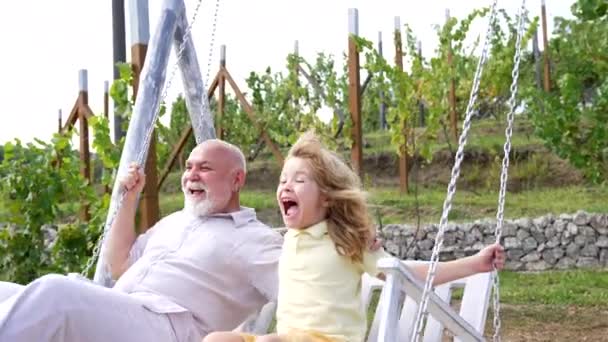 Izgatott fiú és nagyapa boldog kiabálás hintázik együtt a kertben, szórakozás - Felvétel, videó