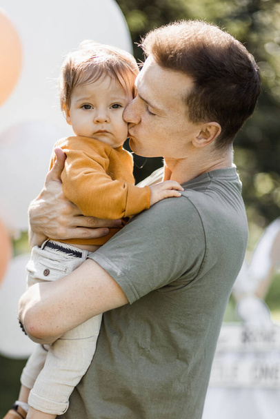 Father kissing and embracing his son near toy teepee tent - Photo, Image
