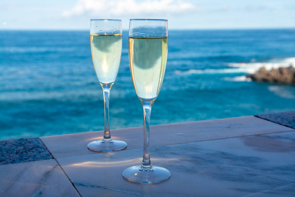 Fête du Nouvel An avec deux verres de champagne ou de vin mousseux cava espagnol et vue sur l'eau bleue de l'océan Atlantique, les îles Canaries, destination touristique d'hiver - Photo, image