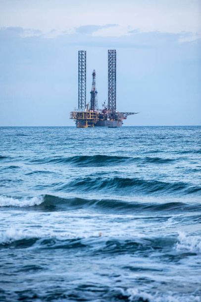 Image en couleur d'une plateforme pétrolière sur mer, au crépuscule. - Photo, image