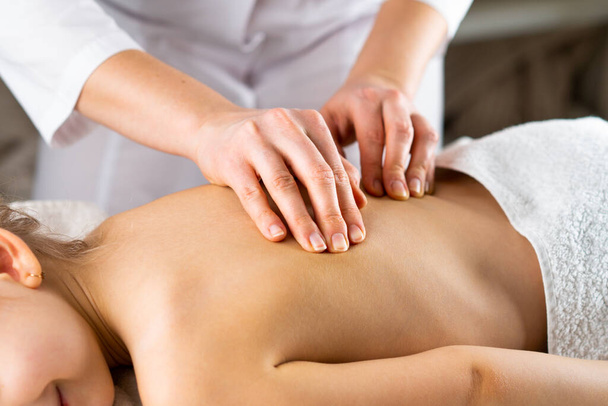 une femme donne un massage à une petite fille, massage des enfants, prévention de la scoliose, ostéopathie - Photo, image