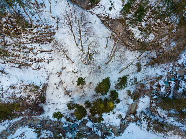 Drop down view of a mountain river flowing through winter forest. - Fotoğraf, Görsel