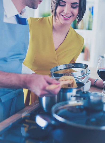 Atrakcyjna para w miłości gotowania i otwiera wino w kuchni podczas gotowania kolacji na romantyczny wieczór - Zdjęcie, obraz