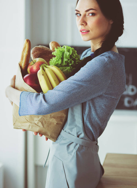 Young woman holding grocery shopping bag with vegetables - Φωτογραφία, εικόνα