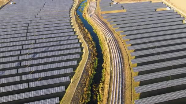 Ilmakuva suuresta kestävästä sähkövoimalasta, jossa on rivejä aurinkosähköpaneeleita puhtaan ekologisen sähköenergian tuottamiseksi. Päästöttömän uusiutuvan sähkön käsite - Materiaali, video