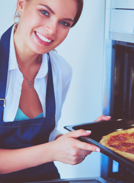 Happy young woman cooking pizza at home - Foto, Imagen