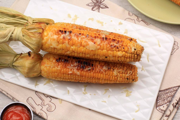 Grilovaná sladká kukuřice s máslem a drcenou mozarellou. Servírováno na bílém podnosu - Fotografie, Obrázek
