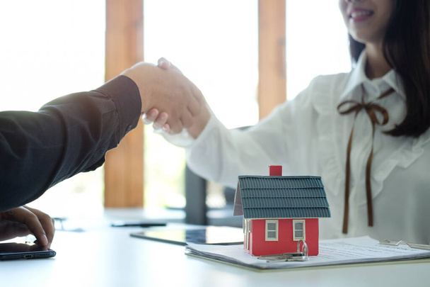 Poignée de main du client avec l'agent immobilier après la signature du contrat. - Photo, image