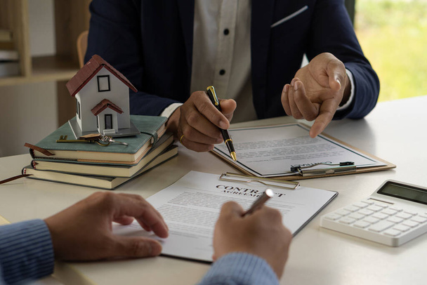 Agent nieruchomości lub urzędnik bankowy wyjaśnia klientowi odsetki od pożyczki z umową pożyczki mieszkaniowej po podpisaniu umowy. koncepcja nieruchomości - Zdjęcie, obraz