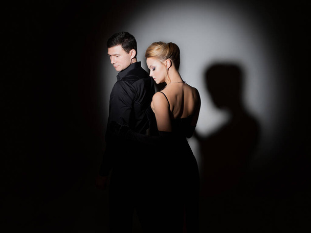 An attractive couple in black. Stylish and elegant young man and woman - Foto, Imagen