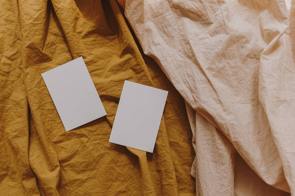 中性パステルエレガントな生姜と桃リネンの布にコピースペースと空白の紙の招待状カード。フラットレイアウト、トップビュー審美的なミニマリストの結婚式の招待 - 写真・画像