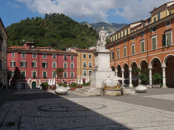 Alberica square in Carrara surrounded by colorful buildings and with the statue dedicated to Beatrice Este made of marble and the lion fountain in the center - Photo, Image