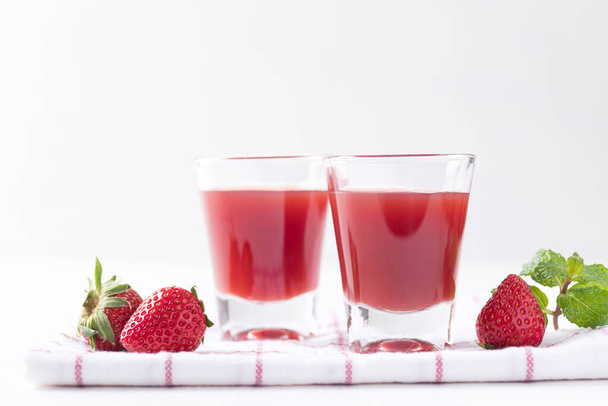 Jus de fraise en verre avec des fraises fraîches sur fond blanc, Boisson saine - Photo, image