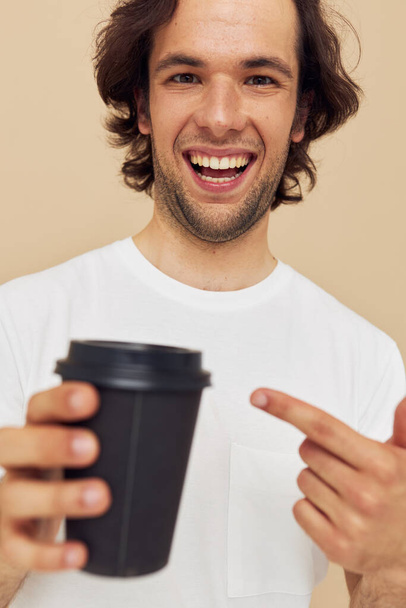 man in a white T-shirt with a black glass in hand Lifestyle unaltered - Photo, Image