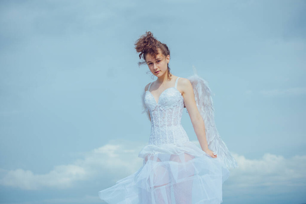 Valentines Day. Love and romance. Teenager angel girl with wings, copy space on sky. - Fotografie, Obrázek