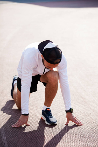 a white man in black shorts and white running at the stadium. workout - Valokuva, kuva